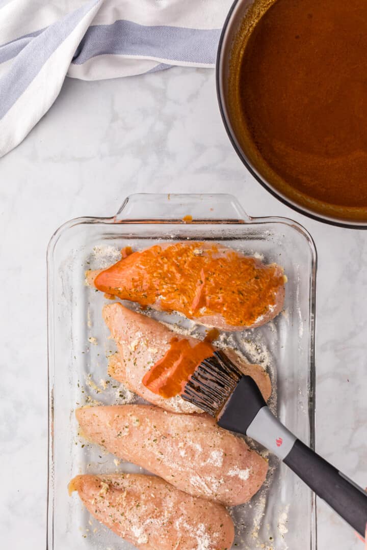 brushing the chicken with the Buffalo sauce.