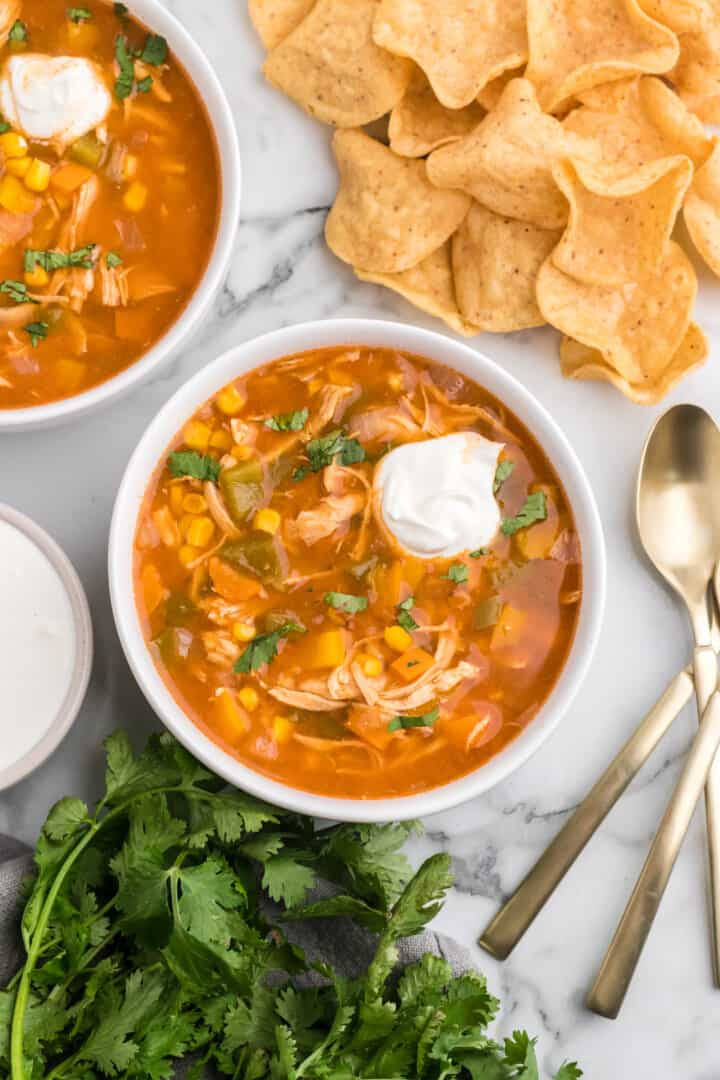 two bowls of chicken fajita soup with tortilla chips.