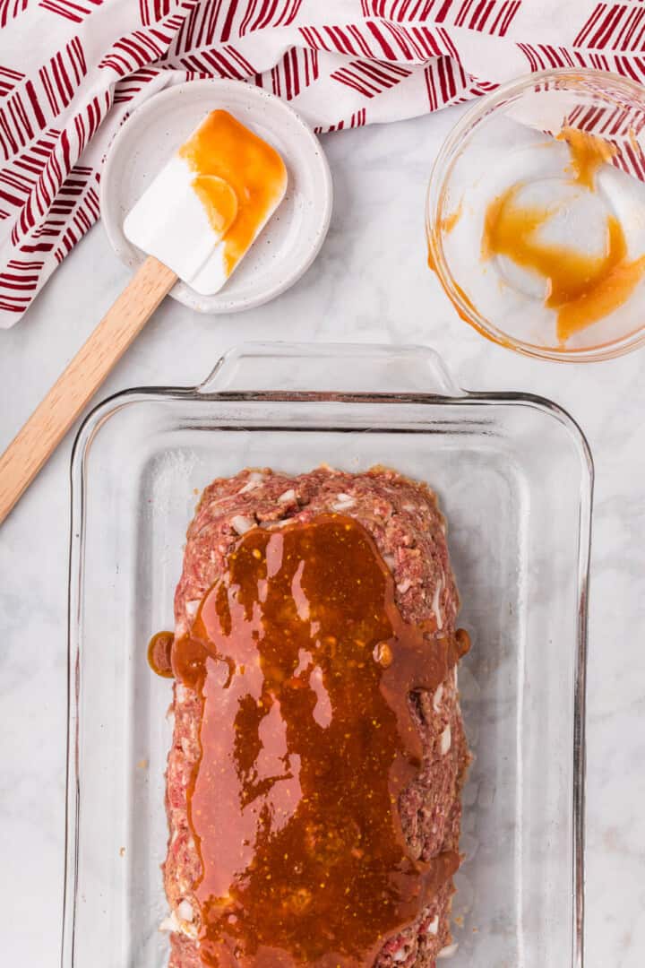 spreading the glaze on top of the meatloaf.