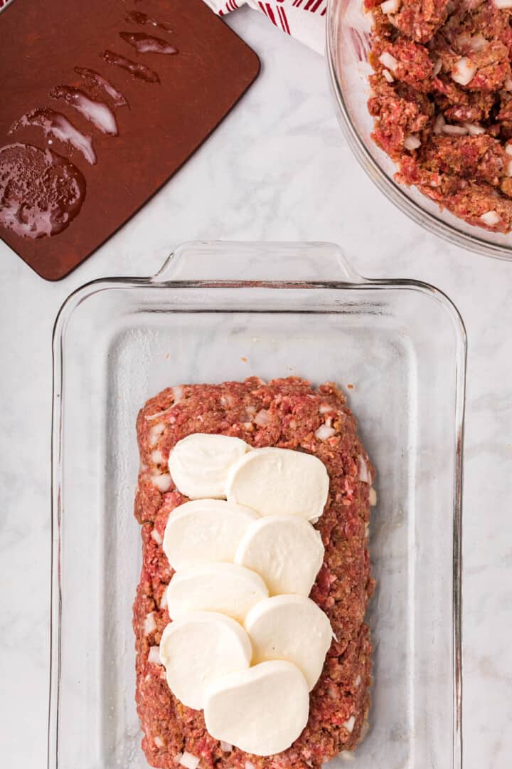 layering the mozzarella cheese in the middle of the meatloaf.