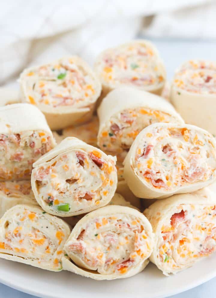 Bacon Ranch Pinwheels stacked on white serving plate.