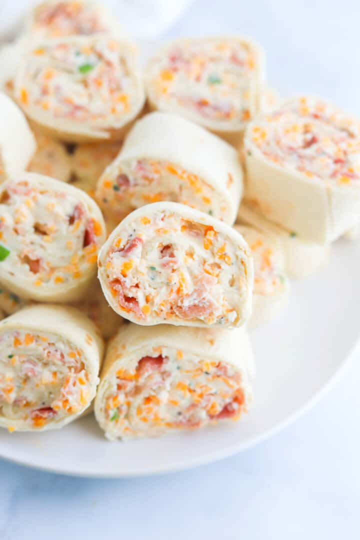 pinwheels stacked on a white plate for serving.