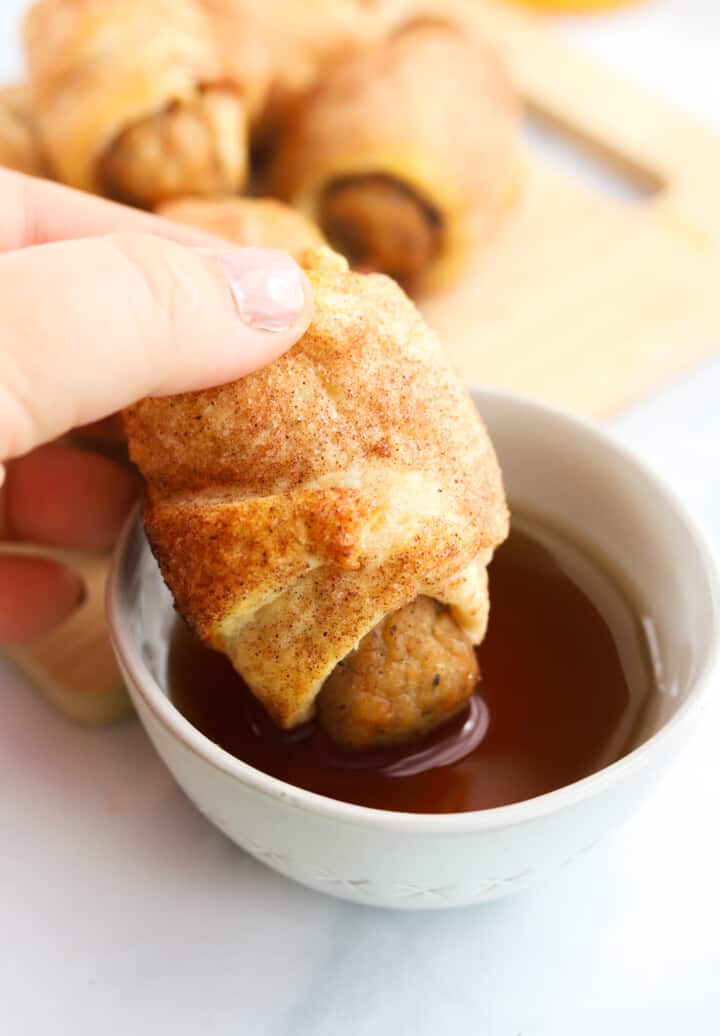 dipping pigs in a blanket into syrup.