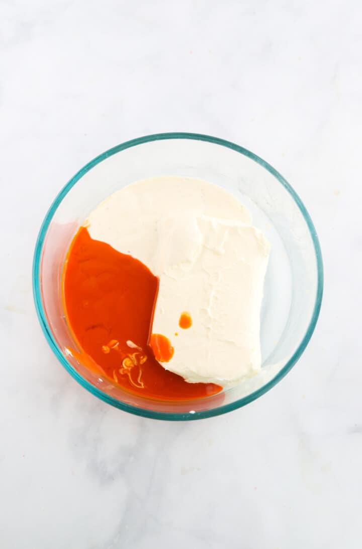 the cream cheese, ranch dressing and buffalo sauce in glass bowl.