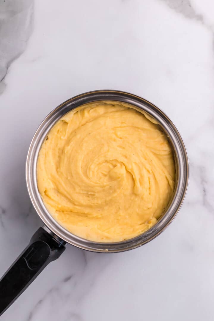 cheesy mashed potatoes mixed in pot.