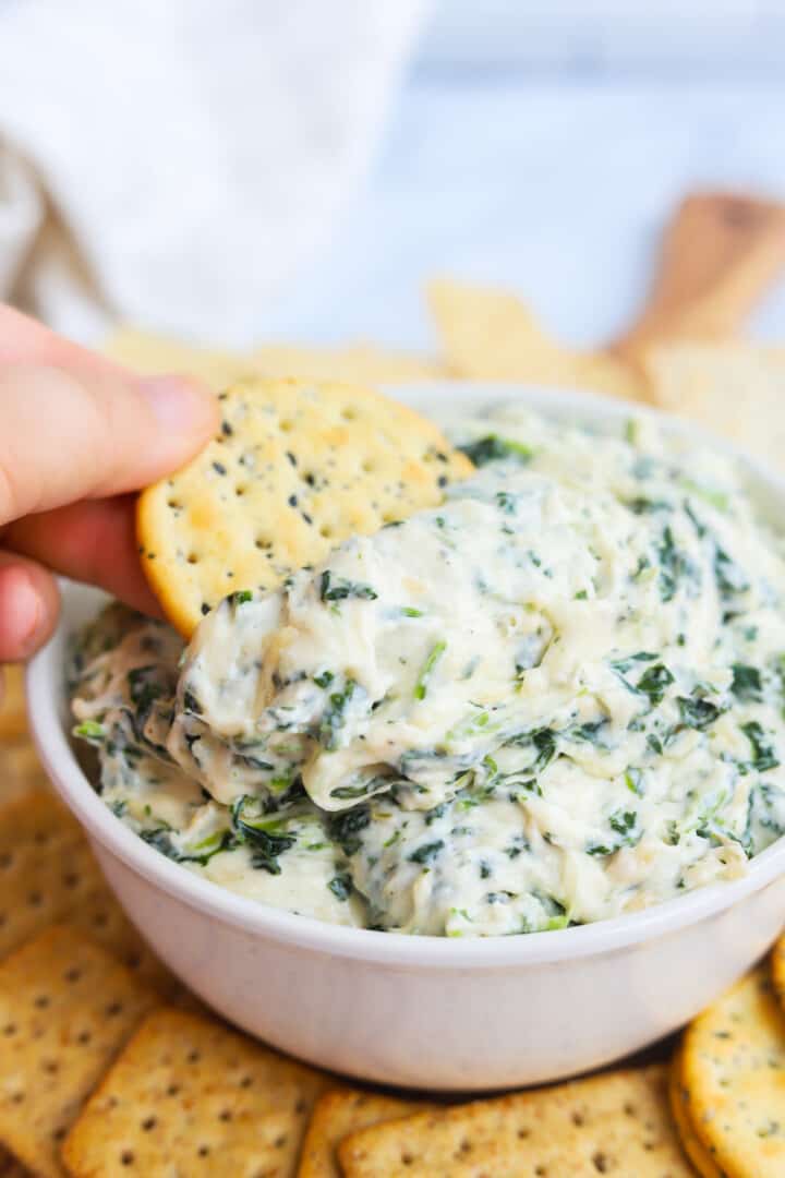 dipping a cracker into the dip.