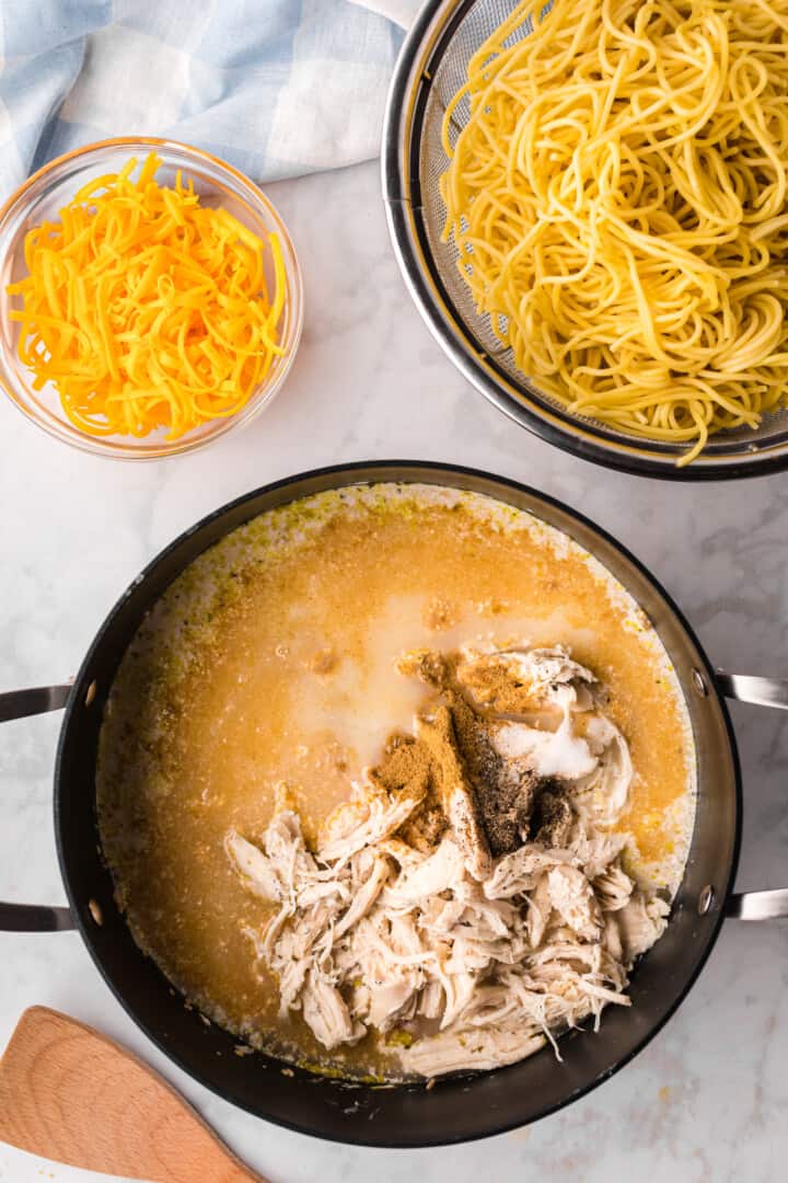 cooking all the ingredients in a large pot with pasta on the side.