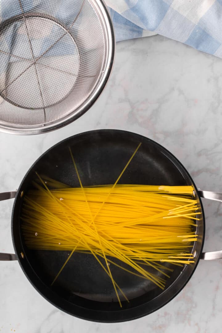 cooking the pasta in a large pot.