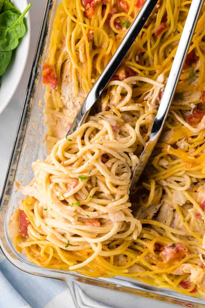 Chicken Spaghetti Casserole being served with tongs.