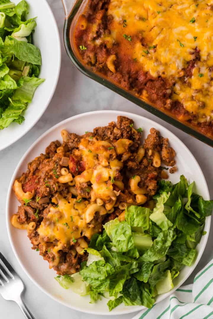 Chili Mac on white plate with salad.