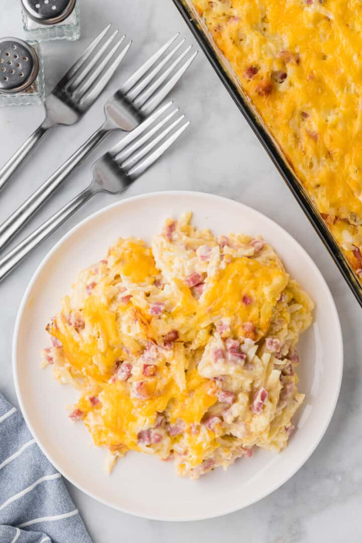 the cheesy ham and potato casserole on a white plate.