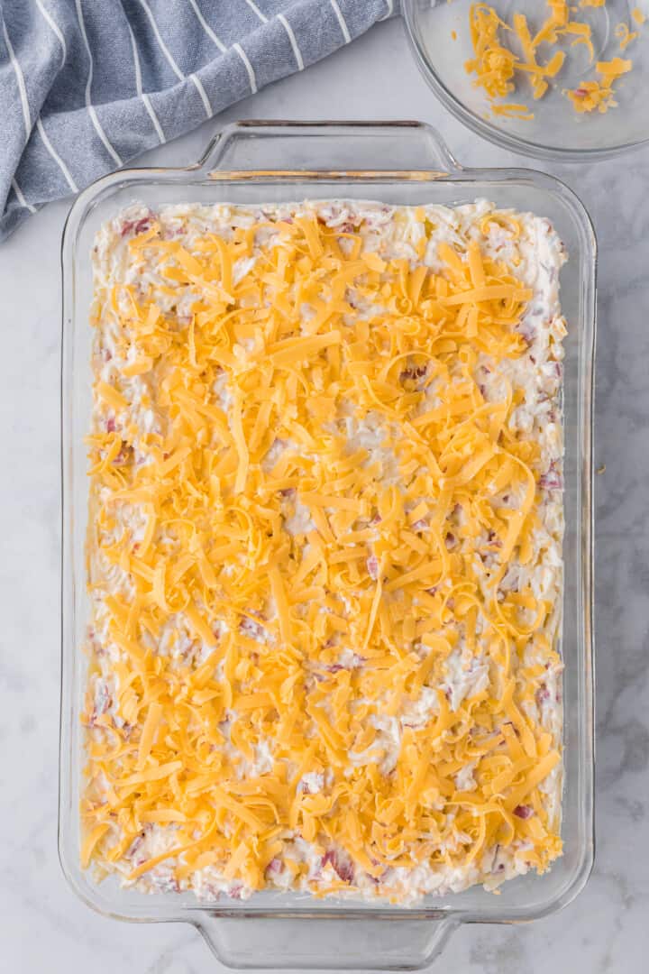 adding all the casserole ingredients to a casserole dish.