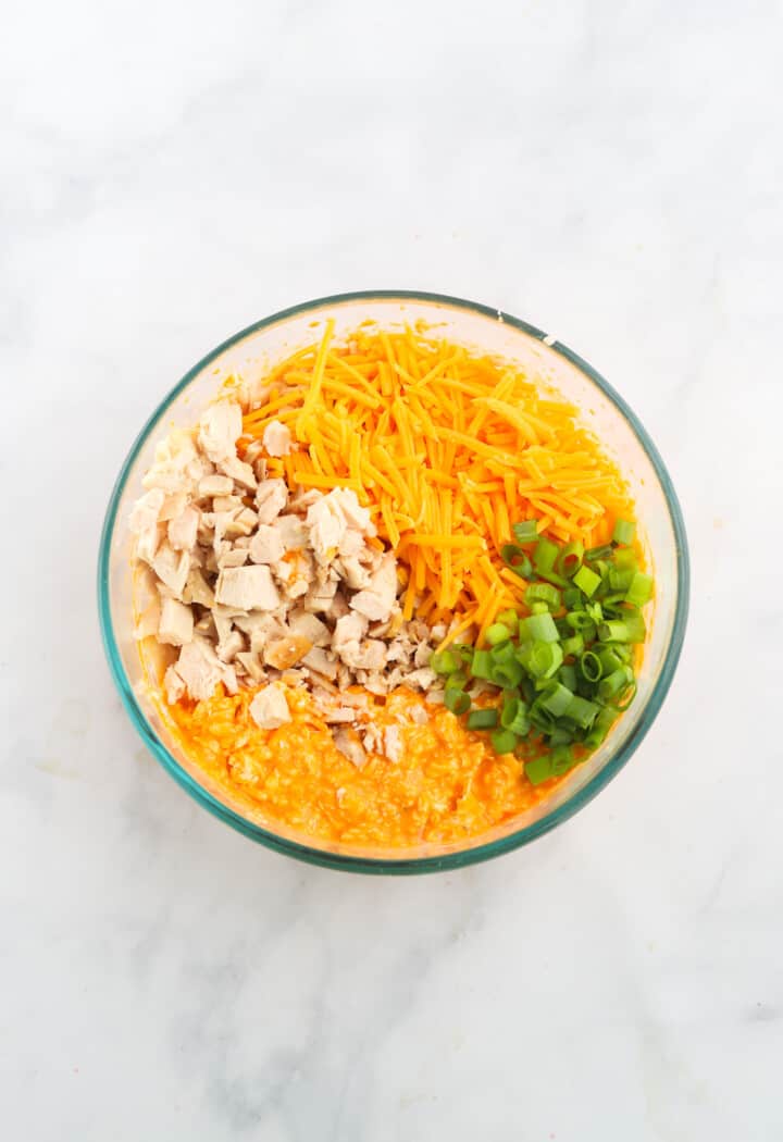 mixing in the chicken, cheese and green onions with the buffalo mixture.