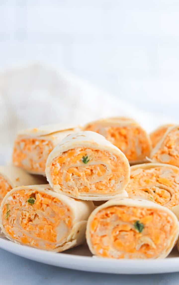 closeup of pinwheels stacked on white plate.