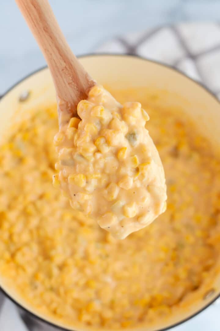 Serving the Cheesy Corn with a wooden spoon.