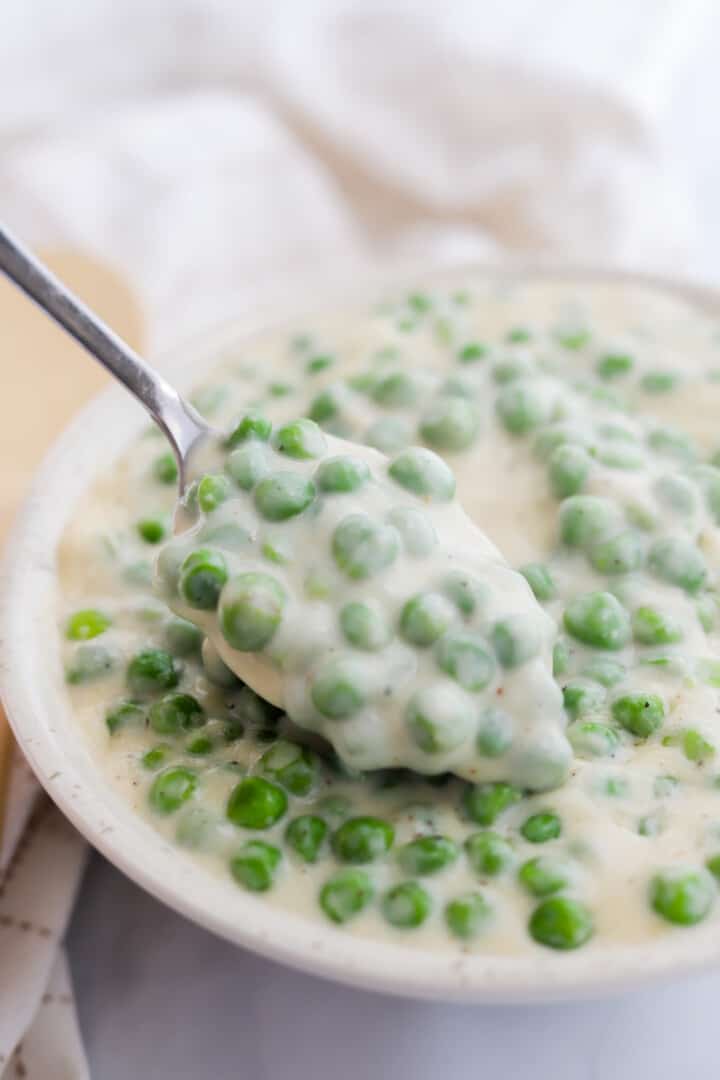 eating the creamed peas with a spoon.