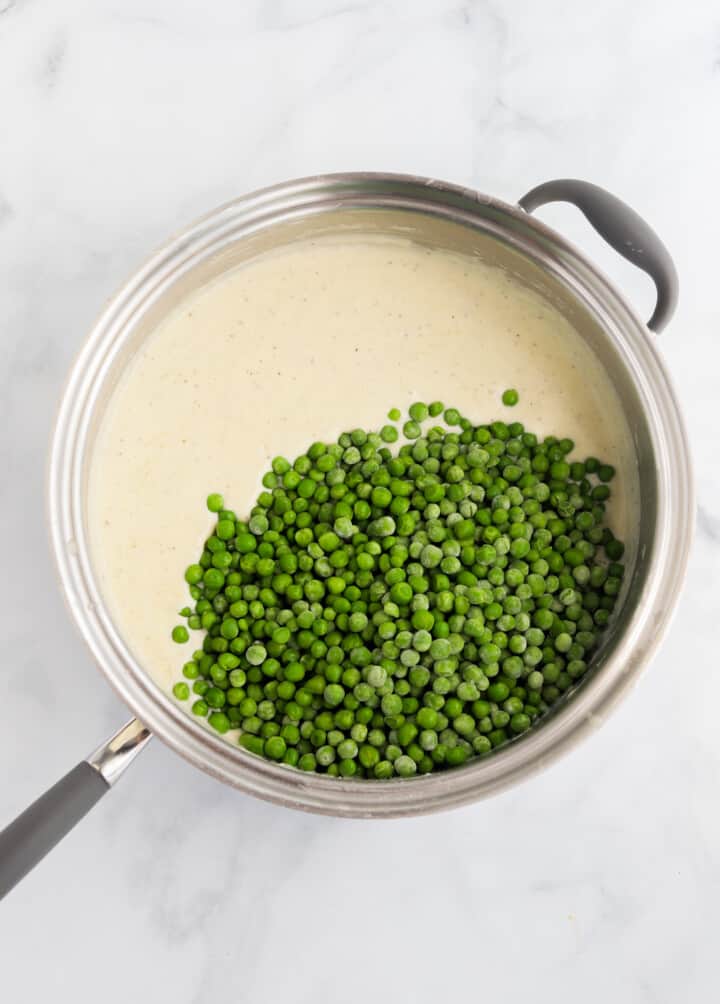 adding the peas to the pan with the cream.