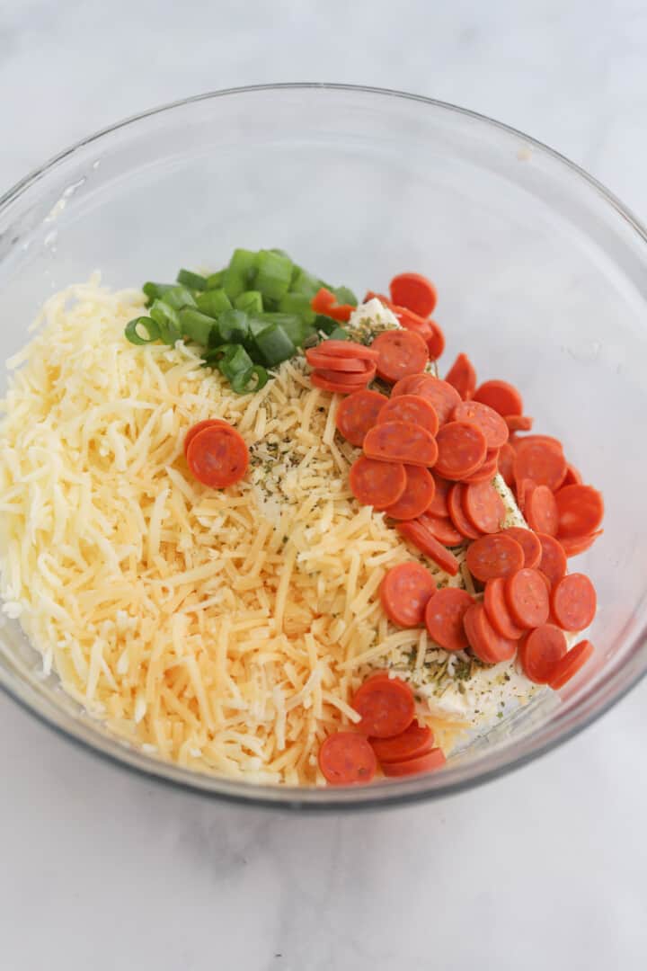 mixing ingredients together in a glass bowl.