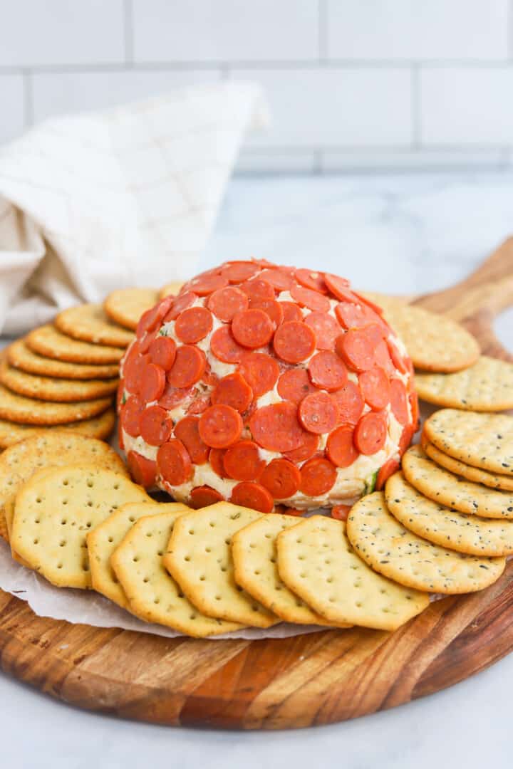 closeup of cheese ball on serving tray with crackers.