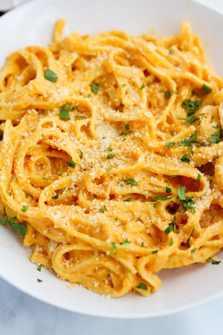 closeup of pumpkin pasta in white bowl.