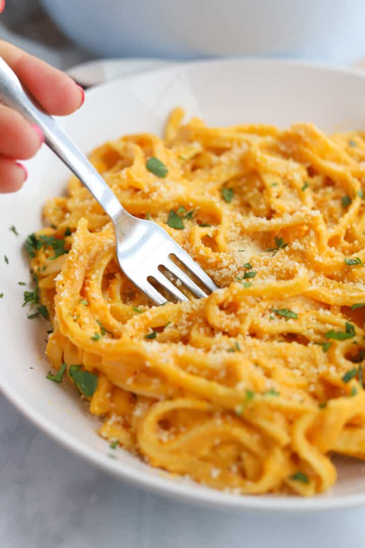 using a fork to eat the pumpkin pasta.