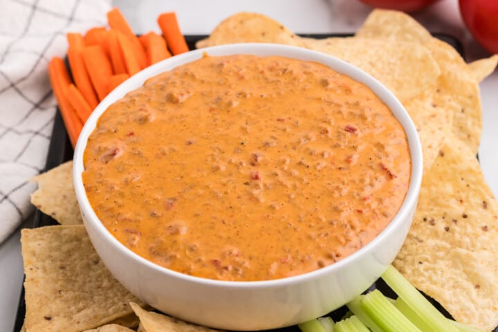 closeup of Rotel Dip in white serving bowl with chips.