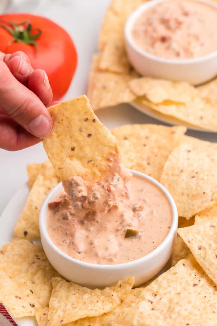 using a tortilla chip to dip in the dip.