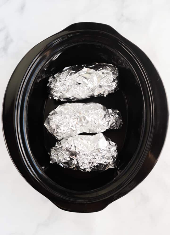 tin foil wrapped potatoes in crock pot.