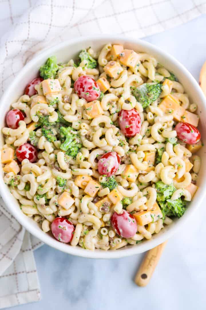 top view of mixed pasta salad in white bowl.