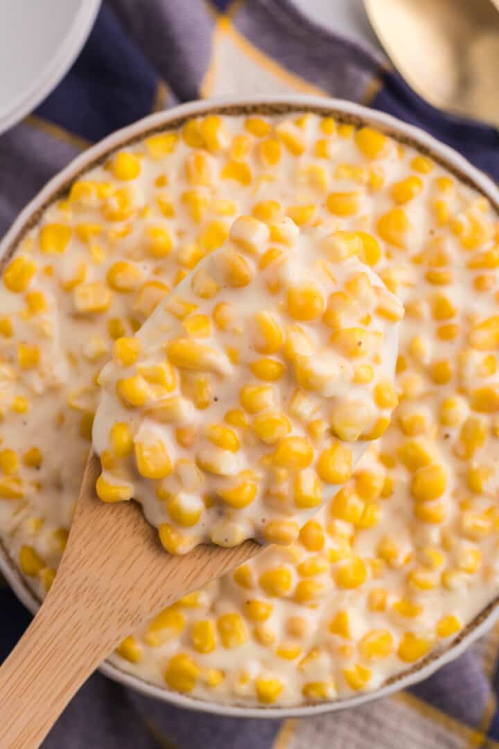 using a wooden spoon to serve the Creamed Corn.