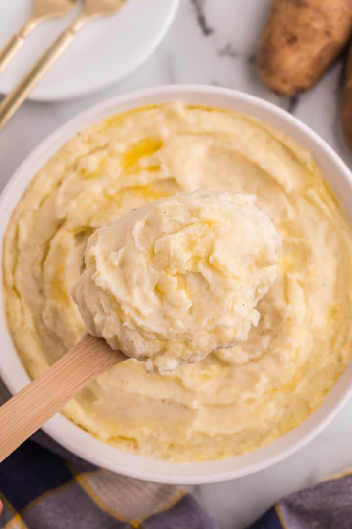 serving the mashed potatoes with a wooden spoon.