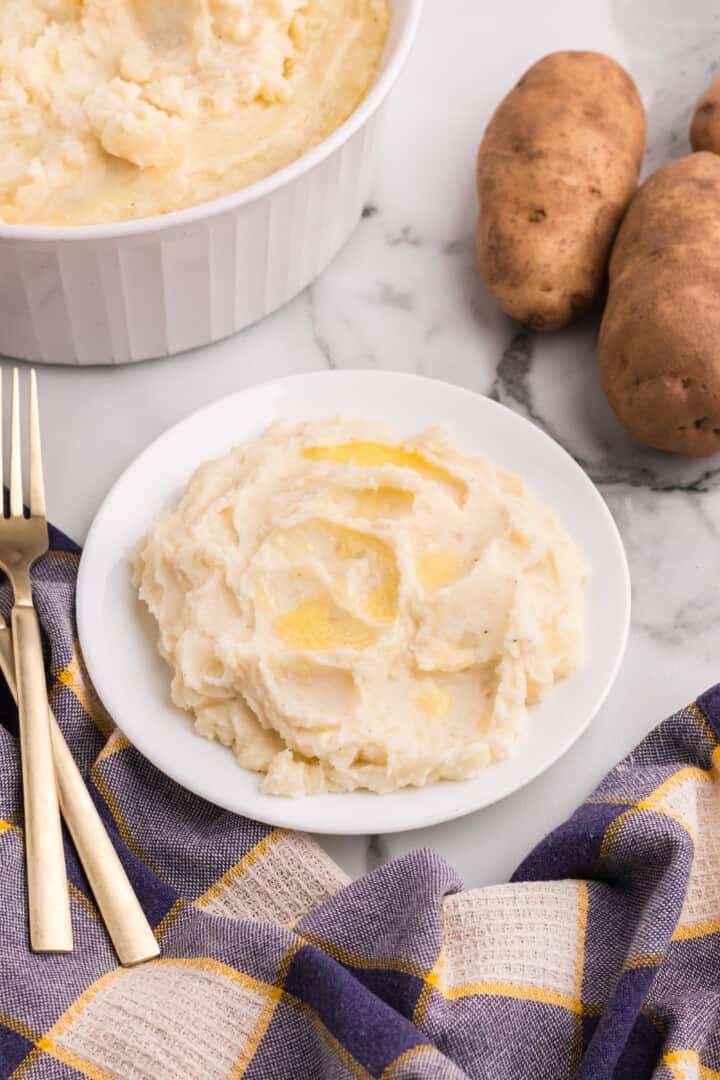 potatoes on a white plate with melted butter on top.