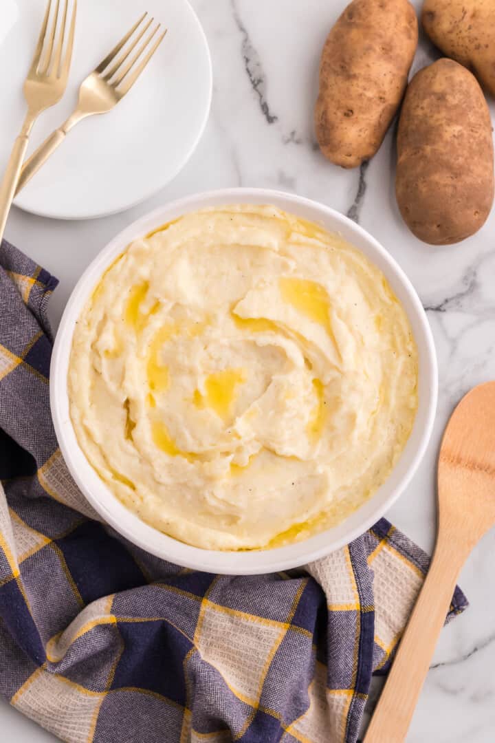 potatoes in white bowl with melted butter on top.