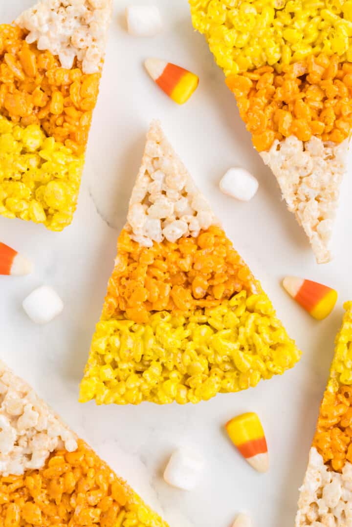 Candy Corn Rice Krispies Treats sliced on counter with candy corn and marshmallows.