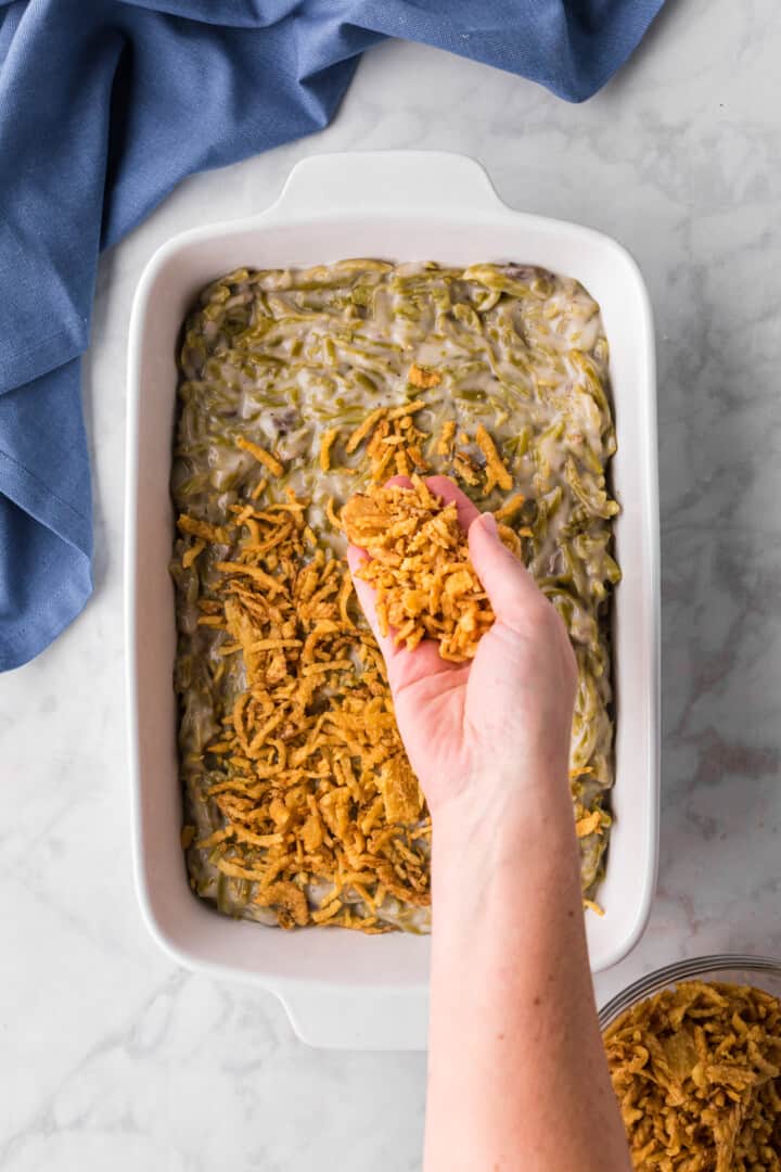 adding the French-Fried Onions to the top of the green bean casserole.