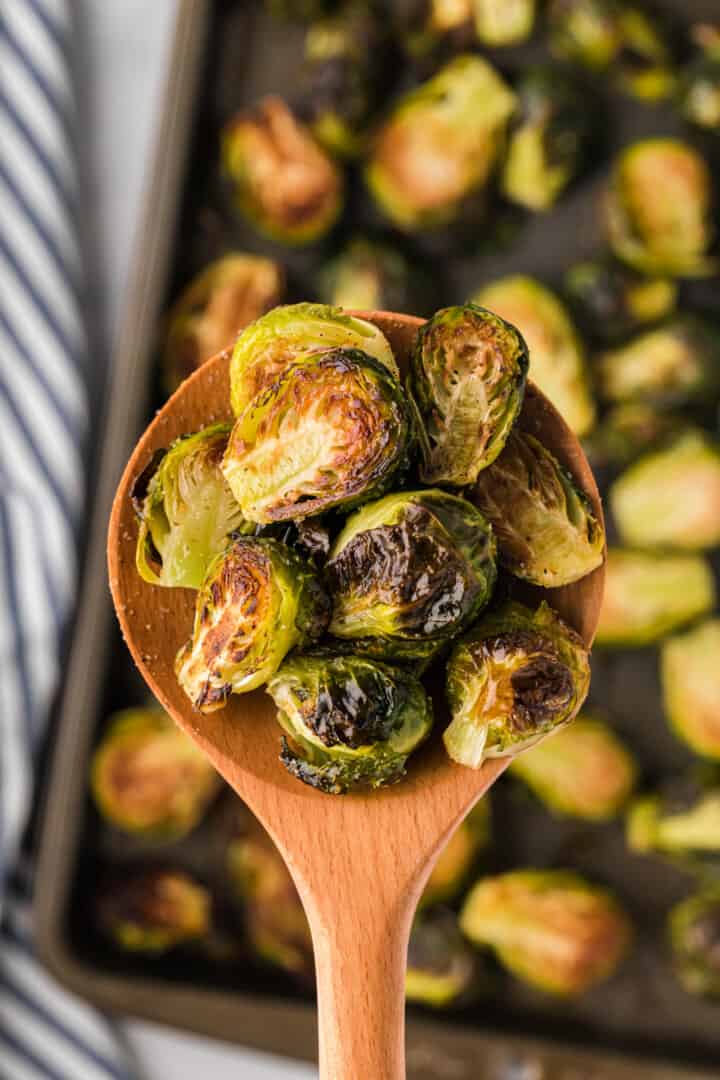 Roasted Brussel Sprouts served on a wooden spoon.