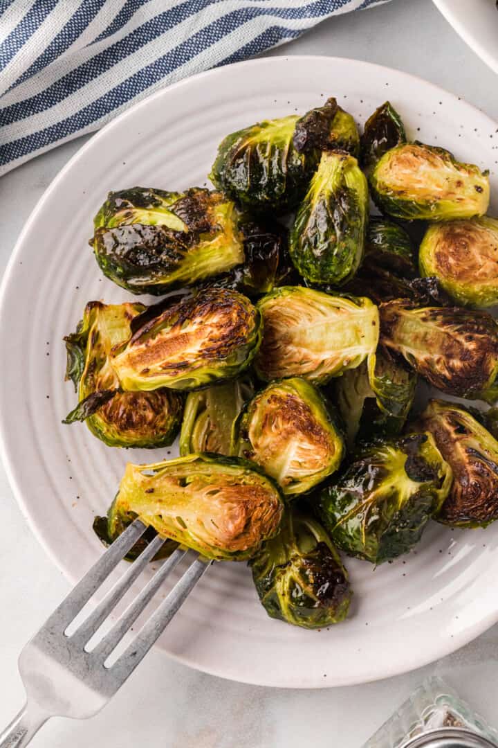 using a fork to eat the Brussel Sprouts.