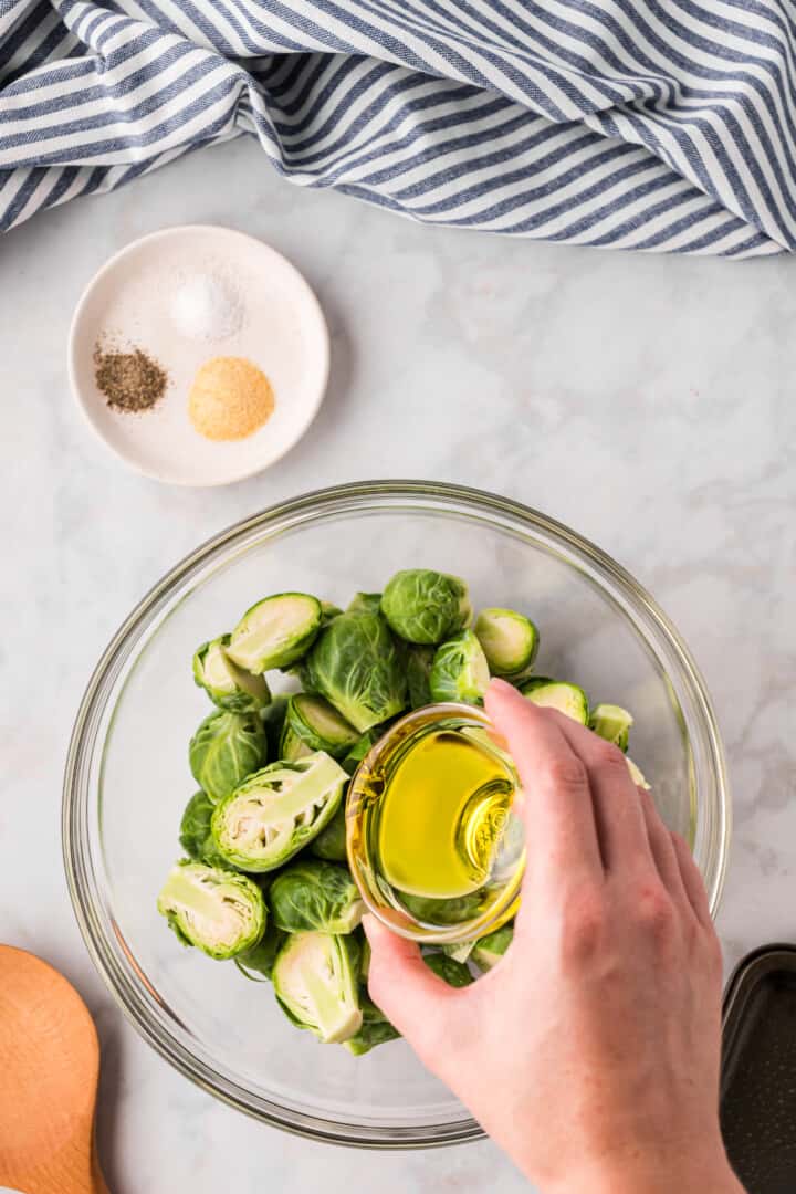 adding the oil to the Brussel Sprouts.