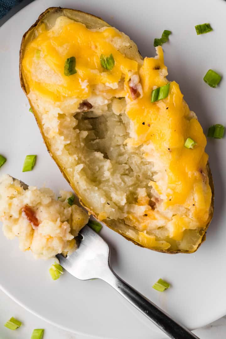 closeup of Twice Baked Potatoes on a white plate.