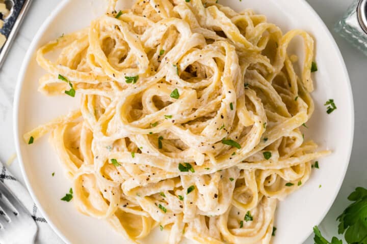 closeup of fettuccini alfredo on a white bowl.