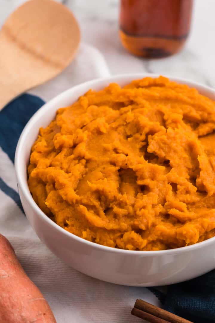 closeup of mashed sweet potatoes in white bowl.