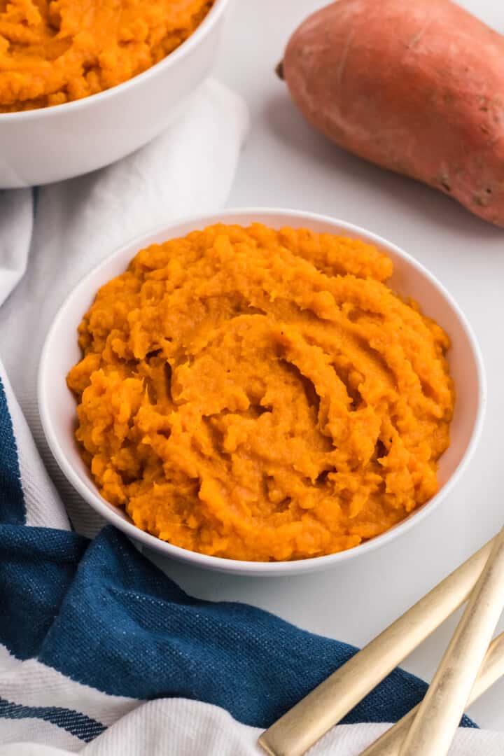 top view of mashed sweet potatoes in white bowl.