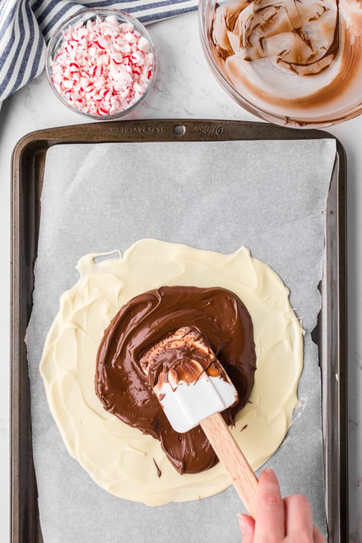 spreading the melted chocolate on top of the frozen white chocolate.