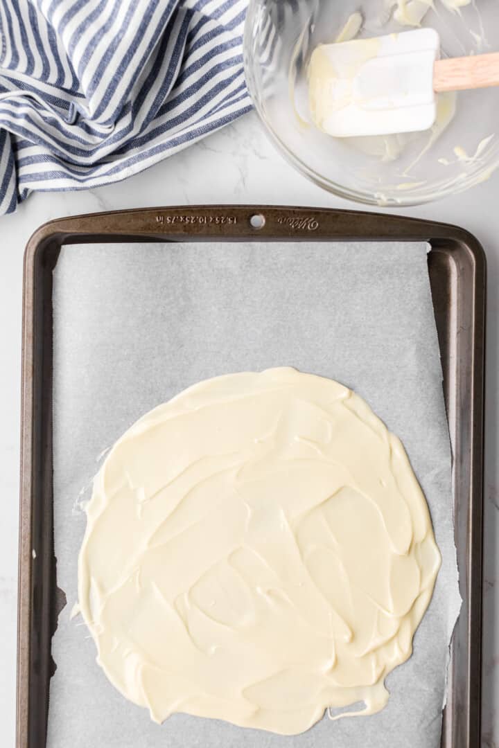 melted white chocolate on baking sheet to freeze.