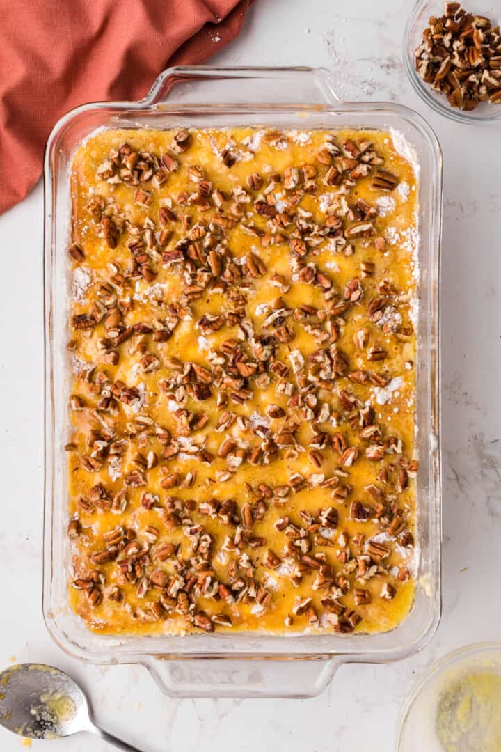 adding pecans to top of the cake.