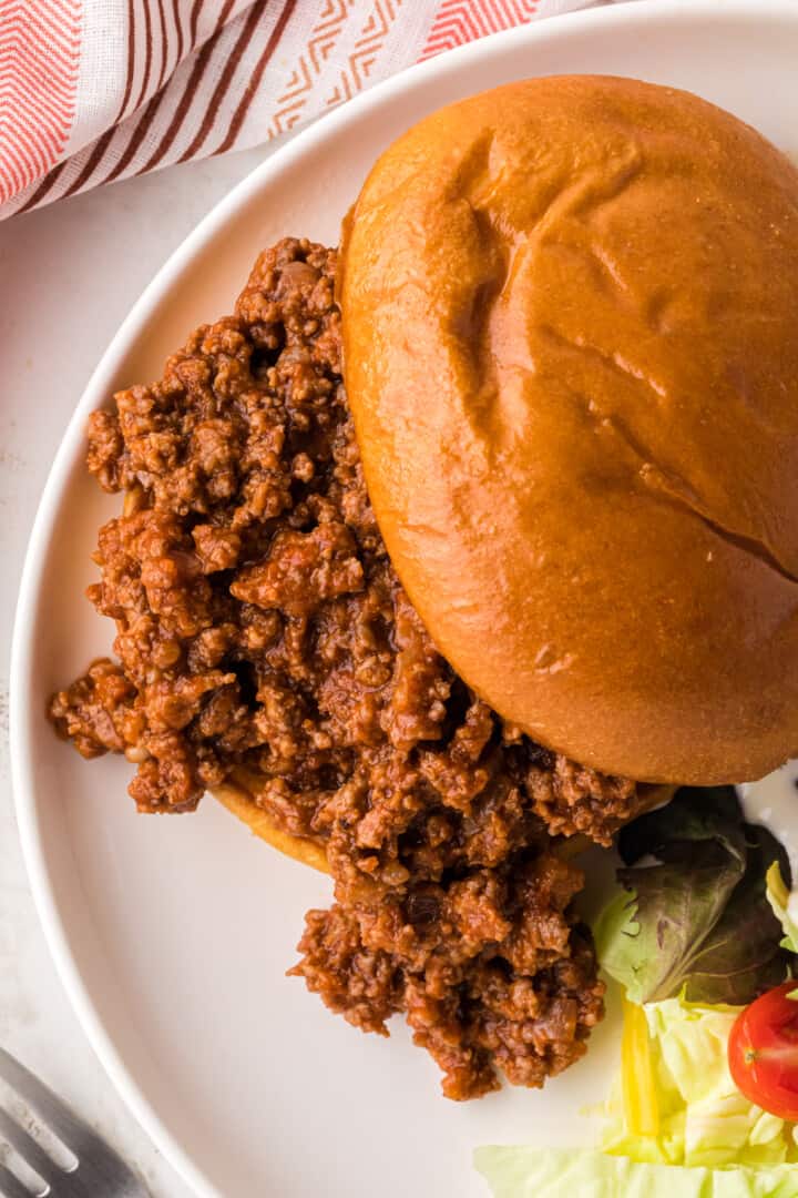 Sloppy Joe sandwich on dinner plate.