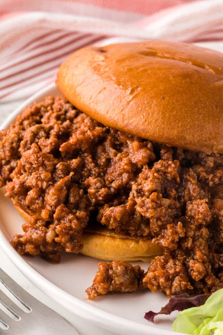 Sloppy Joes made into a sandwich on a plate.