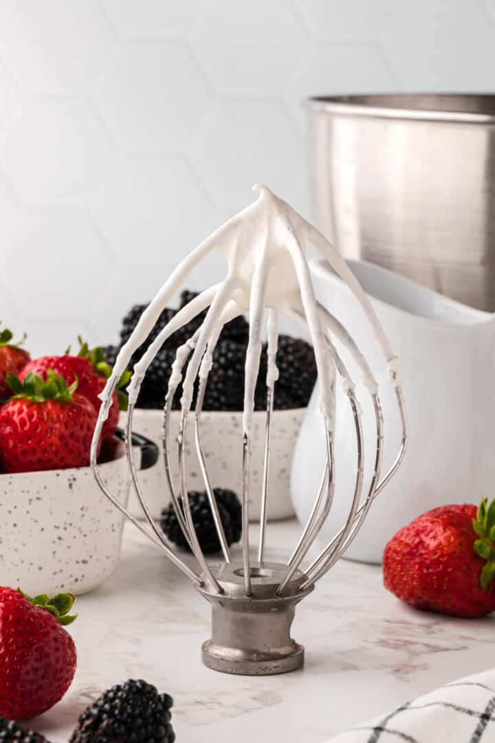 whisk from stand mixer with whipped cream on it.