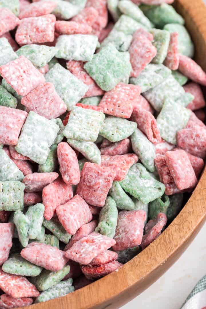 closeup of Christmas Muddy Buddies in wooden bowl.