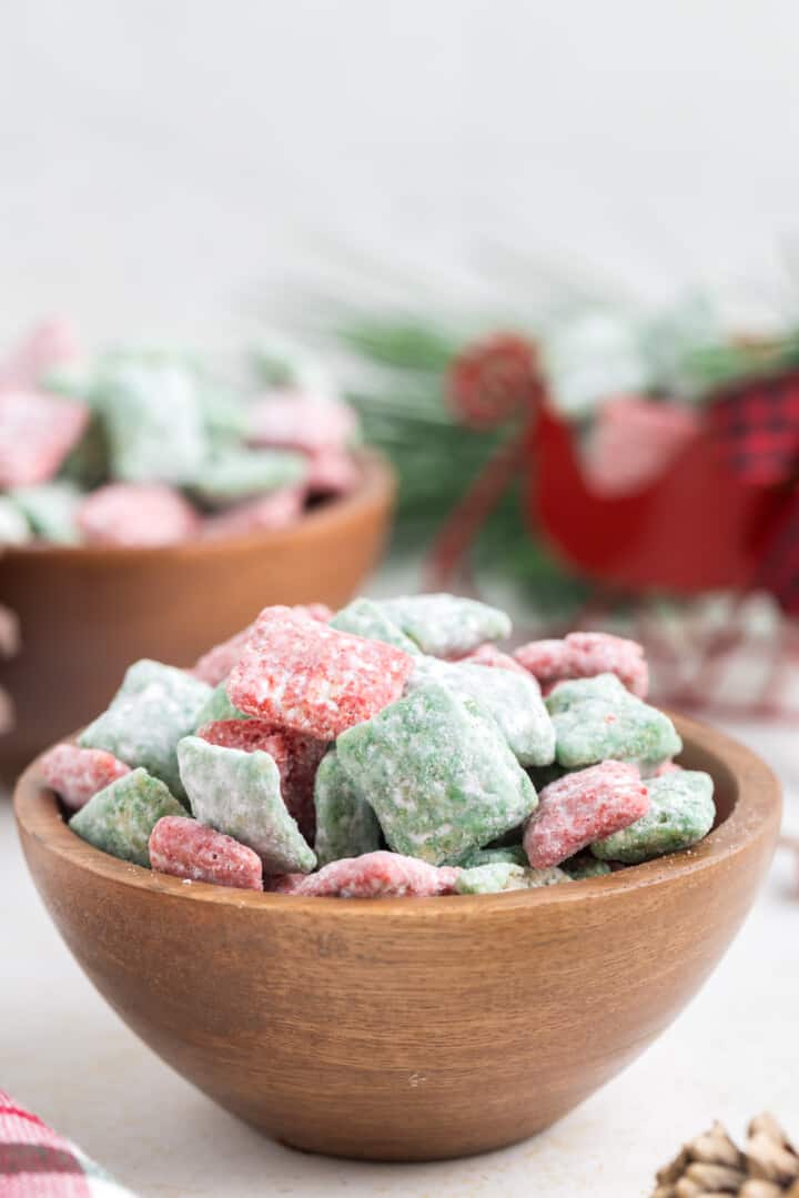 Christmas Muddy Buddies in small wooden bowl for serving.